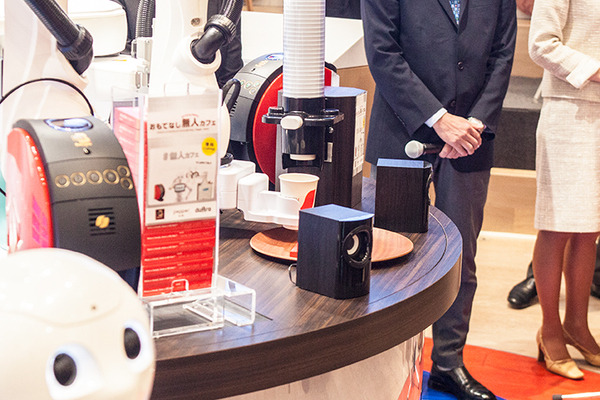 会話ロボットと産業用ロボット、コーヒーマシンが協働して無人でコーヒーを提供する「おもてなし無人カフェ」が期間限定でオープン