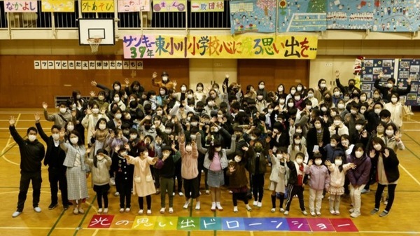 閉校する小学校の夜空に「アリガトウ」の文字が浮かぶ　ドコモ「光の思い出ドローンショー」に歓声が響く