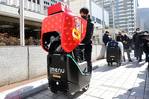 2台の5G自動配送ロボットが西新宿を快走！フードデリバリーと医薬品配送の自動化をめざす　川崎重工/KDDI/タケダ等6社が共同で