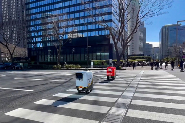 2台の5G自動配送ロボットが西新宿を快走！フードデリバリーと医薬品配送の自動化をめざす　川崎重工/KDDI/タケダ等6社が共同で