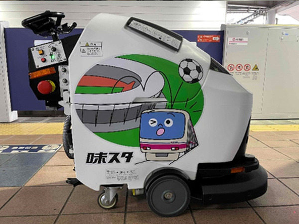 京王電鉄がキャラクター「けい太くん」と味の素スタジアムをラッピングした小型の床洗浄AIロボットを導入　飛田給駅構内で運用