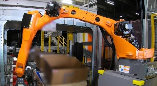 Mujin、日立物流倉庫に3台の知能ロボットを導入 シューズボックスのコンテナ投入・外装箱の処理を「ピースピッカー」で自動化 画像