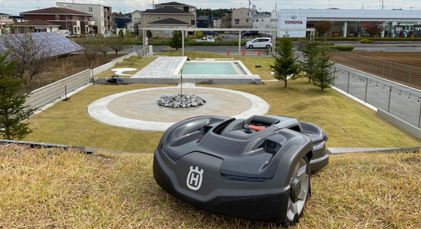 「巨大ロボットの地上絵」が現れるドライブスルー型ショールーム『未来庭苑つくば』オープン　ロボット芝刈り機がショールームを駆け回る 画像