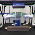 安川電機が双腕ロボットで梱包作業を自動化、模倣学習と強化学習でティーチングレス実現