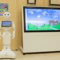 診察の待合室でPepperが大型サイネージと連動、顔認証やVRとの連携も視野にM-SOLUTIONS社の「Smart at robo」を活用