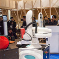 会話ロボットと産業用ロボット、コーヒーマシンが協働して無人でコーヒーを提供する「おもてなし無人カフェ」が期間限定でオープン