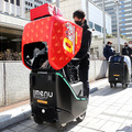 2台の5G自動配送ロボットが西新宿を快走！フードデリバリーと医薬品配送の自動化をめざす　川崎重工/KDDI/タケダ等6社が共同で